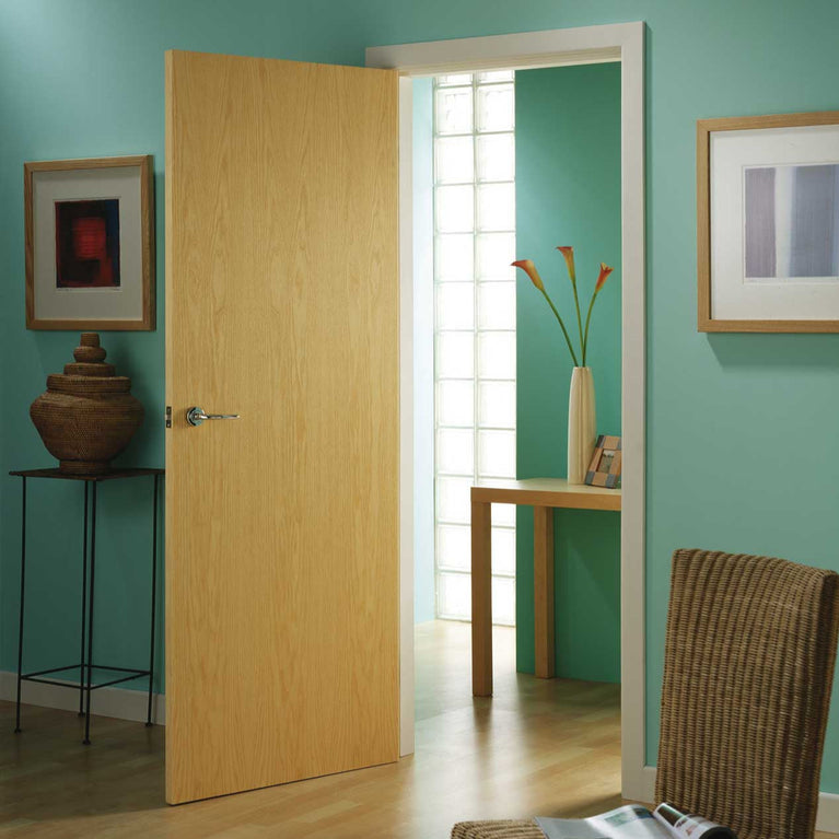 A light oak door in a room with teal walls, a chair, and a small table.