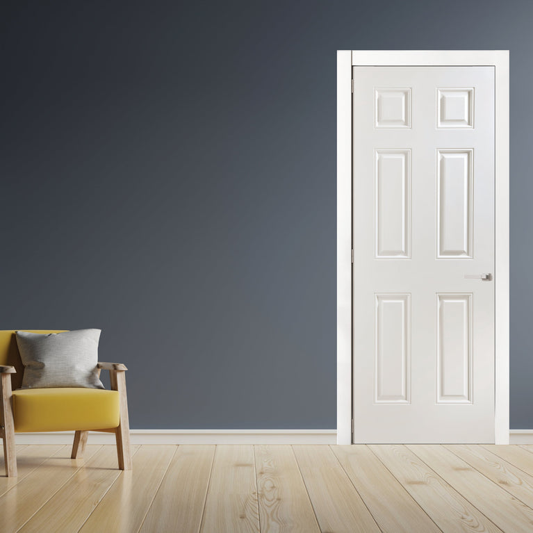 Modern interior featuring a yellow armchair, a white 6-panel door, and a grey wall.