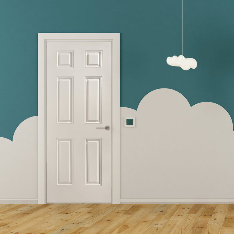 Children's room with a green wall, a white 6-panel door, and colorful toys on a green mat.