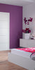 Modern bedroom with white door, purple walls, floral bedding, and a clear chair.