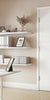 Modern home office with white door in the middle, desk, shelves, and decorative elements.