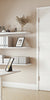 Modern home office with white door in the middle, desk, shelves, and decorative elements.